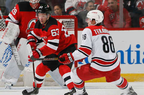 NEWARK, NJ – DECEMBER 29: Jesper Bratt #63 of the New Jersey Devils clears the puck away from Teuvo Teravainen #86 of the Carolina Hurricanes during an NHL hockey game on December 29, 2018, at the Prudential Center in Newark, New Jersey. Devils won 2-0. (Photo by Paul Bereswill/Getty Images)