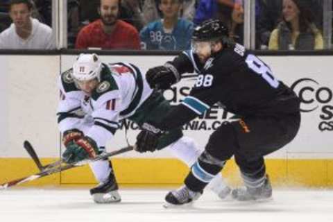 December 11, 2014; San Jose, CA, USA; Minnesota Wild left wing Zach Parise (11) fights for the puck with San Jose Sharks defenseman Brent Burns (88) during the third period at SAP Center at San Jose. The Sharks defeated the Wild 2-1. Mandatory Credit: Kyle Terada-USA TODAY Sports