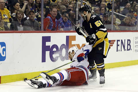 Feb 26, 2022; Pittsburgh, Pennsylvania, USA; New York Rangers right wing Ryan Reaves (75) plays the puck after being knocked to the ice by Pittsburgh Penguins defenseman Kris Letang (58) during the first period at PPG Paints Arena. Mandatory Credit: Charles LeClaire-USA TODAY Sports