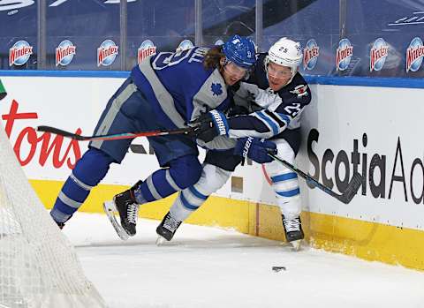 TORONTO, ON – MARCH 9: Paul Stastny #25 of the Winnipeg Jets is checked against the boards by Justin Holl #3 of the Toronto Maple Leafs  (Photo by Claus Andersen/Getty Images)