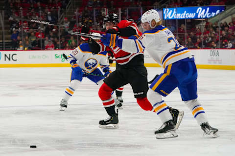 Apr 7, 2022; Raleigh, North Carolina, USA; Buffalo Sabres defenseman Rasmus Dahlin (26) hits Carolina Hurricanes center Martin Necas (88) during the third period at PNC Arena. Mandatory Credit: James Guillory-USA TODAY Sports