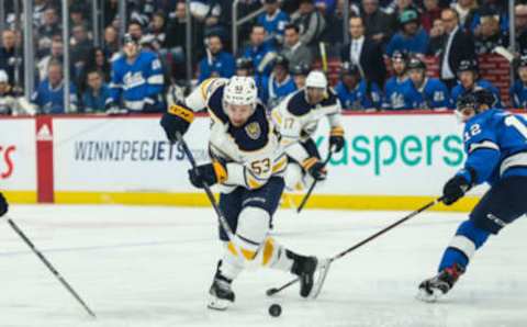 Mar 3, 2020; Winnipeg, Manitoba, CAN; Buffalo Sabres forward Jeff Skinner (53) tries to skates away from Winnipeg Jets defenseman Dylan Demelo (12) during the first period at Bell MTS Place. Mandatory Credit: Terrence Lee-USA TODAY Sports