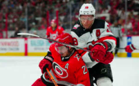 May 11, 2023; Raleigh, North Carolina, USA; Carolina Hurricanes center Sebastian “Fishy”  Aho (20) and New Jersey Devils left wing Ondrej Palat (18) battle for position during the first period in game five of the second round of the 2023 Stanley Cup Playoffs at PNC Arena. Mandatory Credit: James Guillory-USA TODAY Sports