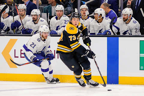 BOSTON, MA – OCTOBER 17: Boston Bruins defenseman Charlie McAvoy (73) skates with the puck as Tampa Bay Lightning center Brayden Point (21) trails the play near Lightning bench during the Tampa Bay Lightning and Boston Bruins NHL game on October 17, 2019, at TD Garden in Boston, MA. (Photo by John Crouch/Icon Sportswire via Getty Images)