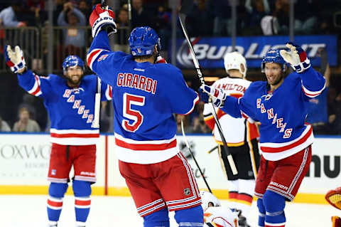 Oct 25, 2015; New York, NY, USA; New York Rangers defenseman Dan Girardi (5) celebrates with his teammates after scoring a second period goal against the Calgary Flames at Madison Square Garden. Mandatory Credit: Andy Marlin-USA TODAY Sports