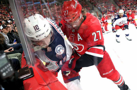 RALEIGH, NC – DECEMBER 16: Justin Faulk #27 of the Carolina Hurricanes battles along the boards with Alexander Wennberg #10 of the Columbus Blue Jackets during an NHL game on December 16, 2017 at PNC Arena in Raleigh, North Carolina. (Photo by Gregg Forwerck/NHLI via Getty Images)