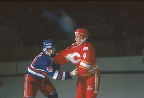 Canadian professional ice hockey player Paul Baxter #4 (right) of the Calgary Flames fights with American Kelly Miller #40 of the New York Rangers on the ice during a pre-season game, San Francisco, October 1986. (Photo by Bruce Bennett Studios/Getty Images)