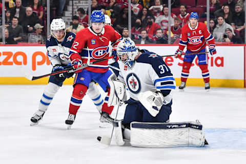 MONTREAL, CANADA – JANUARY 17: Goaltender Connor Hellebuyck #37 of the Winnipeg Jets makes a stick save near Cole Caufield #22 of the Montreal Canadiens during the second period at Centre Bell on January 17, 2023 in Montreal, Quebec, Canada. (Photo by Minas Panagiotakis/Getty Images)