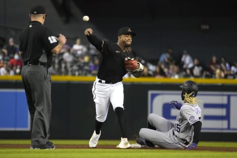 Oct 2, 2021; Phoenix, Arizona, USA; Arizona Diamondbacks second baseman Ketel Marte (4) turns the double play while avoiding Colorado Rockies left fielder Raimel Tapia (15) during the third inning at Chase Field. Mandatory Credit: Rick Scuteri-USA TODAY Sports