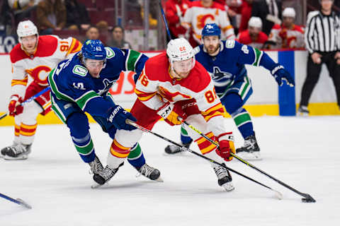 Mar 19, 2022; Vancouver, British Columbia, CAN; Vancouver Canucks defenseman Quinn Hughes (43) stick checks Calgary Flames forward Andrew Mangiapane (88) in the second period at Rogers Arena. Mandatory Credit: Bob Frid-USA TODAY Sports