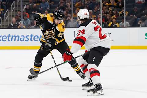 BOSTON, MA – SEPTEMBER 25: Boston Bruins center Par Lindholm (26) controls the puck watched by New Jersey Devils defenseman Ty Smith (24) during a preseason game between the Boston Bruins and the New Jersey Devils on September 25, 2019, at TD Garden in Boston, Massachusetts. (Photo by Fred Kfoury III/Icon Sportswire via Getty Images)