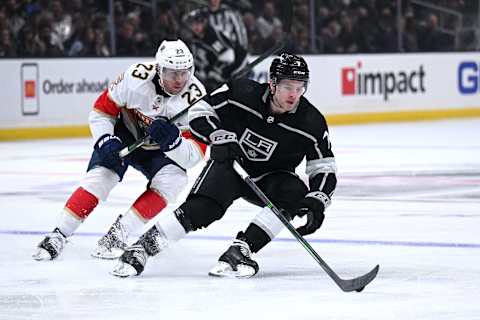 Mar. 13, 2022; Los Angeles, California, USA; Los Angeles Kings defenseman Tobias Bjornfot (7) controls the puck ahead of Florida Panthers center Carter Verhaeghe (23) during the third period at Crypto.com Arena. Mandatory Credit: Orlando Ramirez-USA TODAY Sports