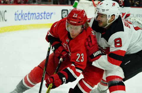 RALEIGH, NC – NOVEMBER 2: Brock McGinn #23 of the Carolina Hurricanes and Will Butcher #8 of the New Jersey Devils battle for a loose puck during an NHL game on November 2, 2019 at PNC Arena in Raleigh, North Carolina. (Photo by Gregg Forwerck/NHLI via Getty Images)