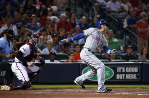 Sep 9, 2016; Atlanta, GA, USA; New York Mets third baseman Kelly Johnson (55) hits a RBI double as Atlanta Braves catcher Tyler Flowers (25) and home plate umpire Phil Cuzzi are shown on the play in the eighth inning of their game at Turner Field. Mandatory Credit: Jason Getz-USA TODAY Sports