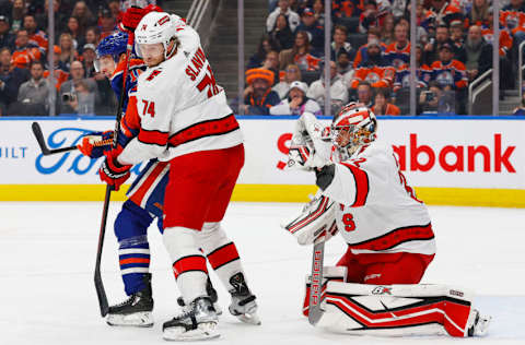 Dec 6, 2023; Edmonton, Alberta, CAN; Edmonton Oilers forward Zach Hyman (18) battles a with Carolina Hurricanes defensemen Jaccob Slavin (74) in front of goaltender Antti Raanta (32) during the first period at Rogers Place. Mandatory Credit: Perry Nelson-USA TODAY Sports