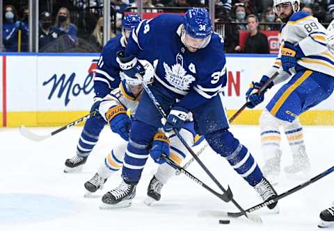 Apr 12, 2022; Toronto, Ontario, CAN; Buffalo Sabres defenseman Jacob Bryson (78) pokes his stick between the legs of Toronto Maple Leafs forward Auston Matthews (34) to disrupt a scoring chance in the third period at Scotiabank Arena. Mandatory Credit: Dan Hamilton-USA TODAY Sports