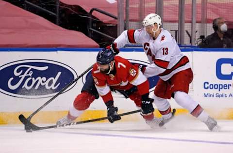 Mar 1, 2021; Sunrise, Florida, USA; Carolina Hurricanes left wing Warren Foegele (13) battles Florida Panthers defenseman Radko Gudas (7) for the puck during the third period at BB&T Center. Mandatory Credit: Jasen Vinlove-USA TODAY Sports