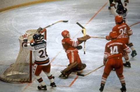 LAKE PLACID, NY – FEBRUARY 22: US hockey players John Harrington (L) and Michael Ramsey (top R) react after the puck was fired into the net for a goal past Soviet goalkeeper Vladimir Myshkin (C) as his teammates Sergei Makarov (top) and Zinetula Bilyaletdinov stand around during the Olympic semifinal match between the USA and the Soviet Union 22 February 1980 in Lake Placid at the Winter Olympic Games. (Photo by STAFF/AFP/Getty Images)