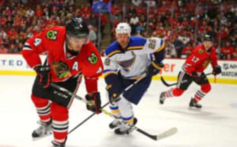 Oct 1, 2016; Chicago, IL, USA; Chicago Blackhawks defenseman Niklas Hjalmarsson (4) and St. Louis Blues center Kyle Brodziak (28) chase the puck during the third period of a preseason hockey game at the United Center. Chicago won 4-0. Mandatory Credit: Dennis Wierzbicki-USA TODAY Sports