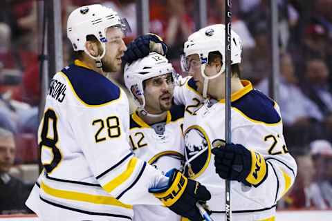 Mar 28, 2016; Detroit, MI, USA; Buffalo Sabres center Zemgus Girgensons (28) receives congratulations from right wing Brian Gionta (12) and left wing Johan Larsson (22) after scoring in the third period against the Detroit Red Wings at Joe Louis Arena. Detroit won 3-2. Mandatory Credit: Rick Osentoski-USA TODAY Sports