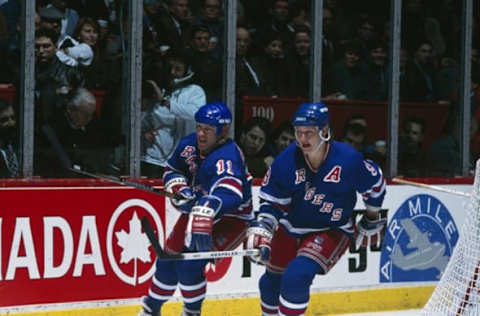 MONTREAL 1990’s: Mark Messier #11 and Adam Graves #9 of the New York Rangers skate for the puck against the Montreal Canadiens in the 1990’s at the Montreal Forum in Montreal, Quebec, Canada. (Photo by Denis Brodeur/NHLI via Getty Images)