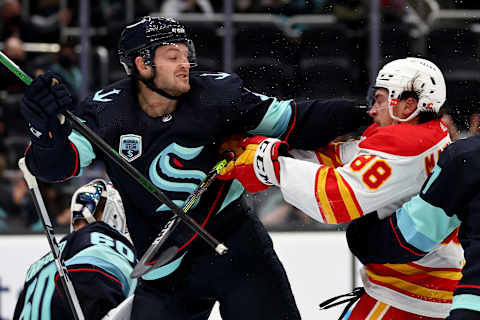 SEATTLE, WASHINGTON – DECEMBER 30: Will Borgen #3 of the Seattle Kraken shoves Andrew Mangiapane #88 of the Calgary Flames during the third period at Climate Pledge Arena on December 30, 2021 in Seattle, Washington. (Photo by Steph Chambers/Getty Images)