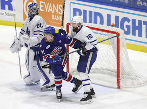 Rochester’s Brett Murray fight for position in front of goalie Joseph Woll and Jordi Benn.