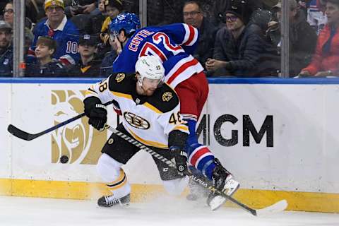 Feb 15, 2022; New York, New York, USA; New York Rangers center Filip Chytil (72) and Boston Bruins defenseman Matt Grzelcyk (48) battle for the puck behind the net during the first period at Madison Square Garden. Mandatory Credit: Dennis Schneidler-USA TODAY Sports