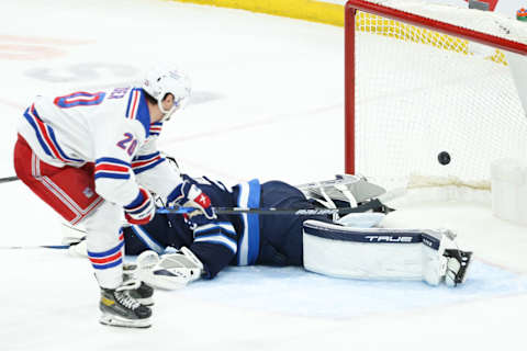 Mar 6, 2022; Winnipeg, Manitoba, CAN; New York Rangers forward Chris Kreider (20) scores on Winnipeg Jets goalie Connor Hellebuyck (37) during the third period at Canada Life Centre. Mandatory Credit: Terrence Lee-USA TODAY Sports