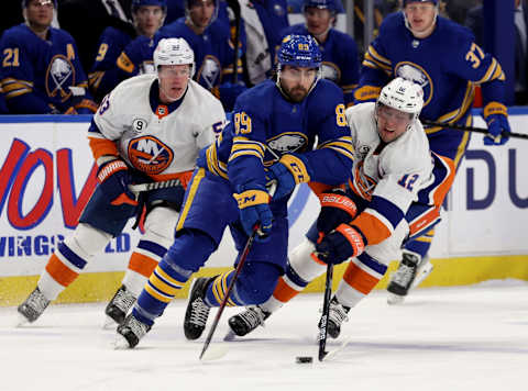 Apr 23, 2022; Buffalo, New York, USA; Buffalo Sabres right wing Alex Tuch (89) tries to control the puck as New York Islanders right wing Josh Bailey (12) knocks it off his stick during the first period at KeyBank Center. Mandatory Credit: Timothy T. Ludwig-USA TODAY Sports