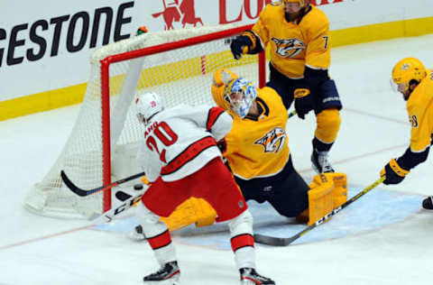 Feb 18, 2020; Nashville, Tennessee, USA; Carolina Hurricanes center Sebastian Aho (20) scores past Nashville Predators goaltender Juuse Saros (74) during the third period at Bridgestone Arena. Mandatory Credit: Christopher Hanewinckel-USA TODAY Sports