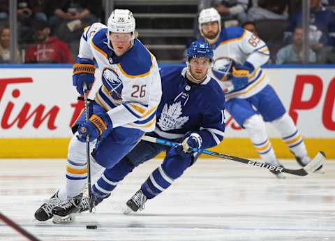 TORONTO, ON – APRIL 12: Rasmus Dahlin #26 of the Buffalo Sabres skates with the puck against Alexander Kerfoot #15 of the Toronto Maple Leafs . (Photo by Claus Andersen/Getty Images)