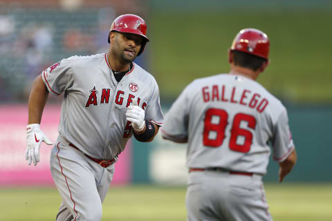 Aug 19, 2019; Arlington, TX, USA; Los Angeles Angels first baseman Albert Pujols (5) is congratulated by third base coach Mike Gallego (86) on his three-run home run against the Texas Rangers during the first inning of a baseball game at Globe Life Park in Arlington. Mandatory Credit: Jim Cowsert-USA TODAY Sports