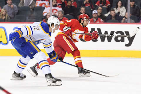 Mar 18, 2022; Calgary, Alberta, CAN; Buffalo Sabres forward Tage Thompson (72) tries to stop a shot from Calgary Flames forward Johnny Gaudreau (13) during the first period at Scotiabank Saddledome. Mandatory Credit: Candice Ward-USA TODAY Sports