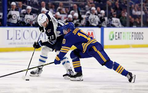 Mar 30, 2022; Buffalo, New York, USA; Buffalo Sabres defenseman Henri Jokiharju (10) tries to knock Winnipeg Jets center Adam Lowry (17) off the puck during the third period at KeyBank Center. Mandatory Credit: Timothy T. Ludwig-USA TODAY Sports