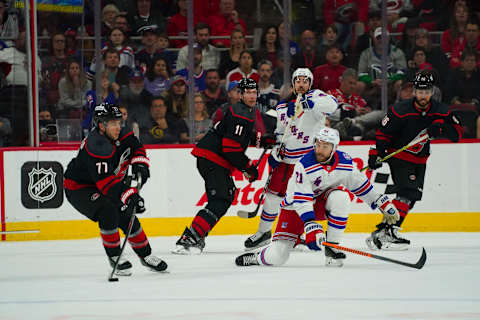 Mar 20, 2022; Raleigh, North Carolina, USA; New York Rangers center Barclay Goodrow (21) goes down to block the lane of Carolina Hurricanes defenseman Tony DeAngelo (77) during the third period at PNC Arena. Mandatory Credit: James Guillory-USA TODAY Sports