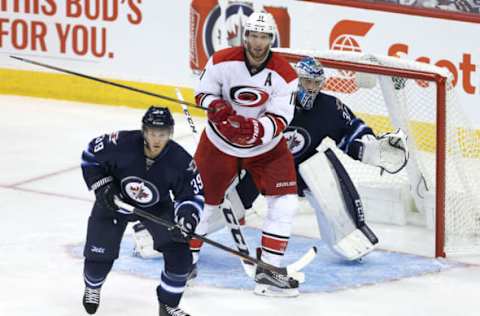 WINNIPEG, MANITOBA – OCTOBER 13: Toby Enstrom #39 and Connor Hellebuyck #37 of the Winnipeg Jets follow the puck as Jordan Staal #11 of the Carolina Hurricanes screens Hellebuyck during NHL action on October 22, 2016, at the MTS Centre in Winnipeg, Manitoba. (Photo by Jason Halstead /Getty Images)