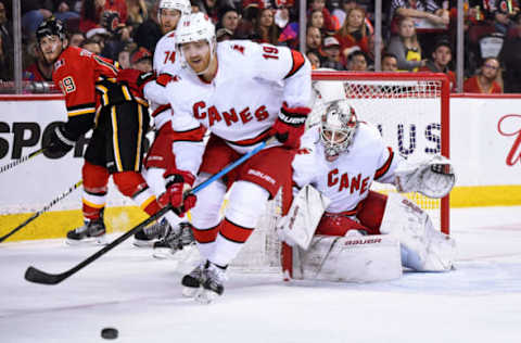 CALGARY, AB – DECEMBER 14: Carolina Hurricanes Goalie James Reimer (47) covers his net without a goal stick as Defenceman Dougie Hamilton (19) tries to clear the puck during the second period of an NHL game where the Calgary Flames hosted the Carolina Hurricanes on December 14, 2019, at the Scotiabank Saddledome in Calgary, AB. (Photo by Brett Holmes/Icon Sportswire via Getty Images)