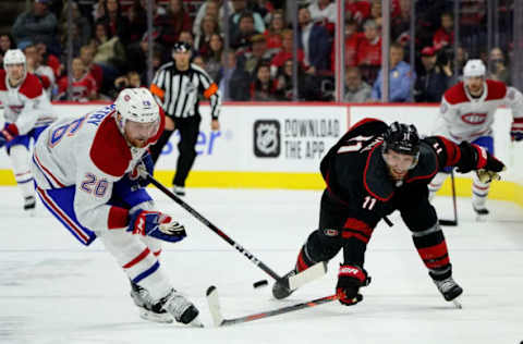 RALEIGH, NC – DECEMBER 31: Jordan Staal #11 of the Carolina Hurricanes battles for a loose puck with Jeff Petty #26 of the Montreal Canadiens during an NHL game on December 31, 2019 at PNC Arena in Raleigh, North Carolina. (Photo by Gregg Forwerck/NHLI via Getty Images)