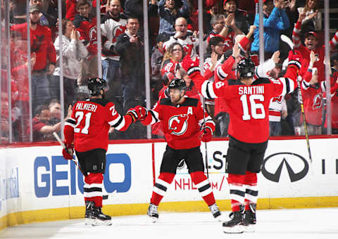 NEWARK, NEW JERSEY – DECEMBER 21: Kyle Palmieri #21 of the New Jersey Devils (l) celebrates his first period goal against the Ottawa Senators along with Taylor Hall #9 (c) and Steven Santini #16 at the Prudential Center on December 21, 2018 in Newark, New Jersey. (Photo by Bruce Bennett/Getty Images)