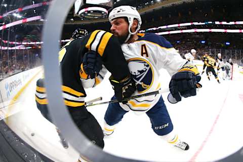 BOSTON, MA – DECEMBER 16: Zach Bogosian #4 of the Buffalo Sabres checks Danton Heinen #43 of the Boston Bruins into he boards in the first period of the game between the Boston Bruins and the Buffalo Sabres at TD Garden on December 16, 2018 in Boston, Massachusetts. (Photo by Maddie Meyer/Getty Images)