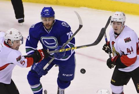 Feb 25, 2016; Vancouver, British Columbia, CAN; Vancouver Canucks forward Emerson Etem (26) battles for the puck against Ottawa Sentators defenseman Cody Ceci (5) and forward Jean-Gabriel Pageau (44) during the second period at Rogers Arena. Mandatory Credit: Anne-Marie Sorvin-USA TODAY Sports