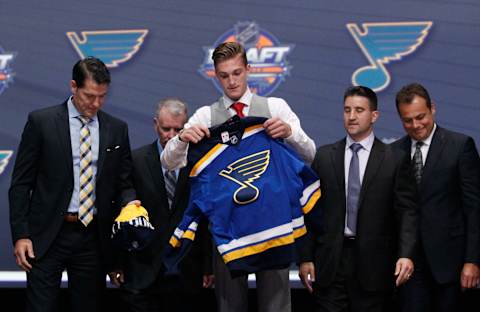 Jun 24, 2016; Buffalo, NY, USA; Tage Thompson puts on a team jersey after being selected as the number twenty-six overall draft pick by the St. Louis Blues in the first round of the 2016 NHL Draft at the First Niagra Center. Mandatory Credit: Timothy T. Ludwig-USA TODAY Sports