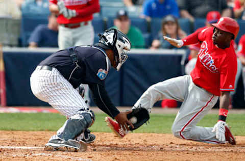 Mar 3, 2016; Tampa, FL, USA; Philadelphia Phillies Quinn (71) slides safely into home plate as New York Yankees catcher Carlos Corporan (17) drops the ball while trying to tag him during the sixth inning at George M. Steinbrenner Field. Mandatory Credit: Butch Dill-USA TODAY Sports