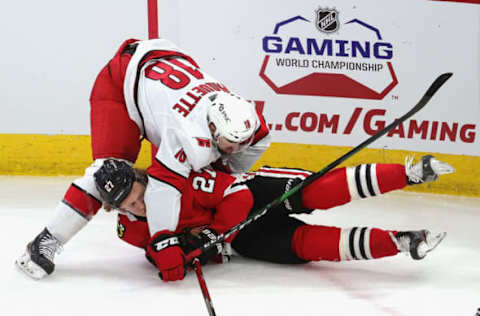 CHICAGO, ILLINOIS – MARCH 30: Cedric Paquette #18 of the Carolina Hurricanes tosses Adam Boqvist #27 of the Chicago Blackhawks to the ice at the United Center on March 30, 2021 in Chicago, Illinois. (Photo by Jonathan Daniel/Getty Images)