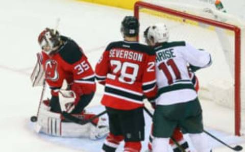 Oct 22, 2016; Newark, NJ, USA; New Jersey Devils goalie Cory Schneider (35) makes a save while Minnesota Wild left wing Zach Parise (11) and New Jersey Devils defenseman Damon Severson (28) battle during the third period at Prudential Center. The Devils defeated the Wild 2-1 in overtime. Mandatory Credit: Ed Mulholland-USA TODAY Sports