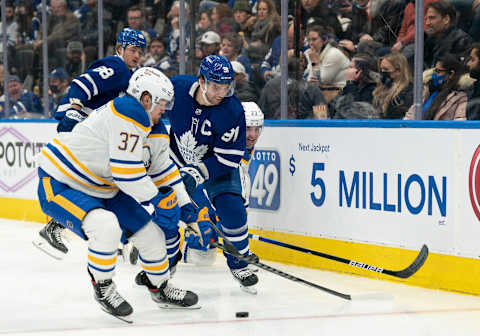 Mar 2, 2022; Toronto, Ontario, CAN; Toronto Maple Leafs center John Tavares (91) battles for the puck with Buffalo Sabres center Casey Mittelstadt (37) during the third period at Scotiabank Arena. Mandatory Credit: Nick Turchiaro-USA TODAY Sports