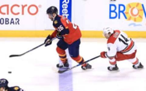 Apr 9, 2016; Sunrise, FL, USA; Florida Panthers right wing Teddy Purcell (26) skates with the puck past Carolina Hurricanes left wing Nathan Gerbe (14) in the third period at BB&T Center. The Panthers won 5-2. Mandatory Credit: Robert Mayer-USA TODAY Sports