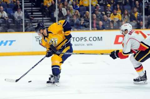 Dec 15, 2015; Nashville, TN, USA; Nashville Predators center Cody Hodgson (11) draws a hooking penalty by Calgary Flames defenseman T.J. Brodie (7) on a break away during the first period at Bridgestone Arena. Mandatory Credit: Christopher Hanewinckel-USA TODAY Sports