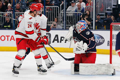 Jan 12, 2023; Columbus, Ohio, USA; Carolina Hurricanes center Seth Jarvis (24) looks for a rebound as Columbus Blue Jackets goalie Joonas Korpisalo (70) makes the save during the first period at Nationwide Arena. Mandatory Credit: Russell LaBounty-USA TODAY Sports